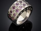 a close up of a silver ring with purple and white diamonds