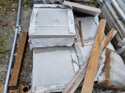 un tas de vieilleries par terre, près d'une clôture