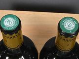 four bottles of wine are in a wooden holder on a table