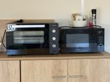 two microwaves that are sitting on top of a cabinet