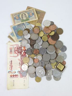 a pile of coins and money on a white surface
