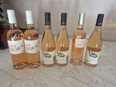 Plusieurs bouteilles de vin sont alignées sur un comptoir en marbre