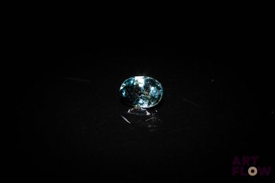 a close up of a blue diamond on a black surface