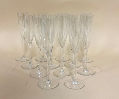 six verres à vin transparents sont alignés sur une surface blanche
