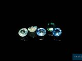 a close up of three different colored gems on a black surface