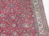 an image of a red rug with a blue border on a white background
