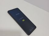 the back of a black phone sitting on top of a white table