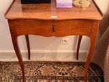 a small wooden table with a lamp on top of it