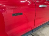 a close up of a red car with a sticker on it