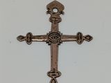 un gros plan d'une croix posée sur une table, sur fond blanc