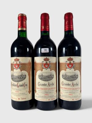trois bouteilles de vin sont alignées sur une surface blanche