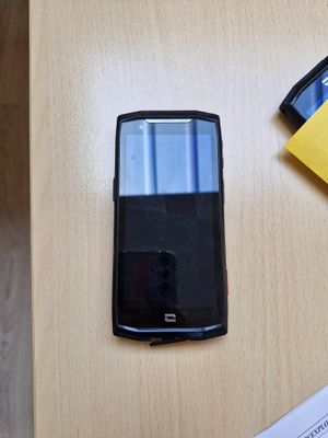 un téléphone portable posé sur une table à côté d'une feuille de papier