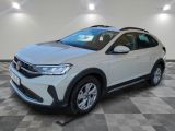 un SUV Volkswagen blanc garé sur un sol à damier dans un garage