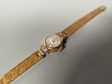 une montre-bracelet en or avec un cadran blanc et un bracelet en or