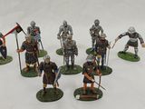 several figurines of knights with spears and shields on a white surface