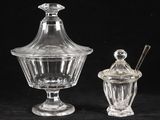 deux bocaux en verre transparent avec leurs couvercles et leurs cuillères, posés sur une surface noire