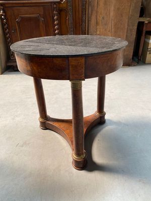 an image of a round table with a marble top and wooden legs