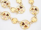 a close up of a gold necklace with hearts on it
