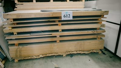 Plusieurs piles de bois sont empilées les unes sur les autres dans un entrepôt.