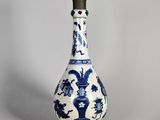 un vase bleu et blanc avec un couvercle noir posé sur une table