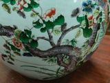 a vase on a table that has flowers and birds on it