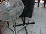 a table with a fan on it and a trash can in the background