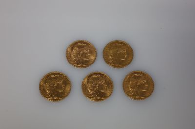 quatre pièces d'or sont disposées en ligne sur une surface blanche