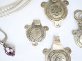 several different types of silver jewelry on a white surface