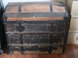 an old chest sitting on the floor next to a dresser