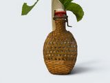 a wicker vase with a flower in it on a table
