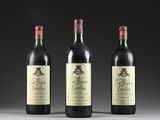 three bottles of wine are lined up on a table