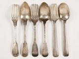six spoons and a fork are lined up on a white surface