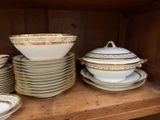 many plates and bowls on a shelf in a cabinet
