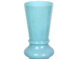 un vase bleu posé sur une surface blanche