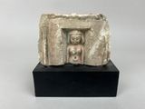 une ancienne statue en pierre représentant une femme dans une embrasure de porte