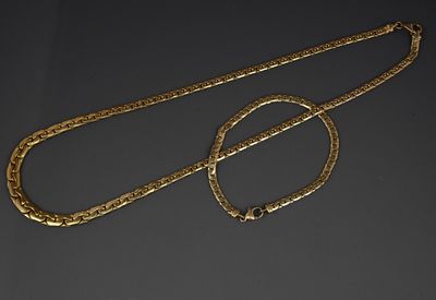two gold chains and a necklace on a black surface