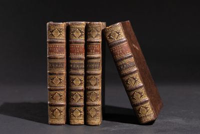 trois vieux livres sont empilés sur une table
