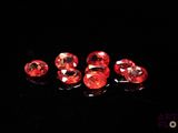 a group of red diamonds sitting on top of a black surface