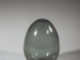a green glass ball sitting on a white surface