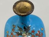a blue vase with a bird and flowers design on it