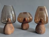 three glass vases with wooden bases on a table