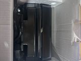 a refrigerator that is open and has a black refrigerator inside of it
