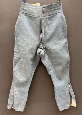 grey pants hanging on a clothes line on a brown surface
