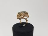 a close up of a gold ring with a green stone in it