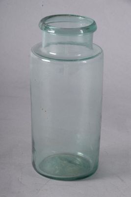 un bocal en verre muni d'un couvercle, posé sur une surface blanche