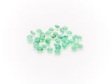 a pile of green emerald gems on a white background