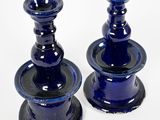 two blue candlesticks sitting on a white surface