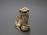 a small figurine of a dragon sitting on top of a ball