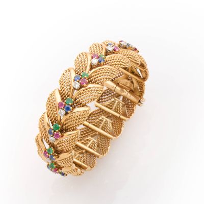 a close up of a gold bracelet with multi colored stones