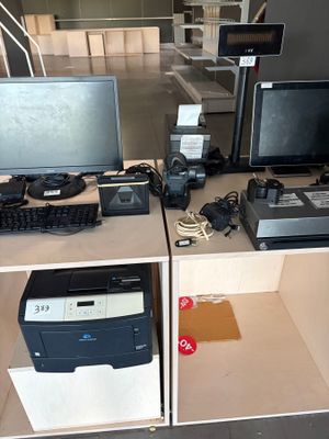 un bureau sur lequel se trouvent un ordinateur, une imprimante et d'autres appareils électroniques